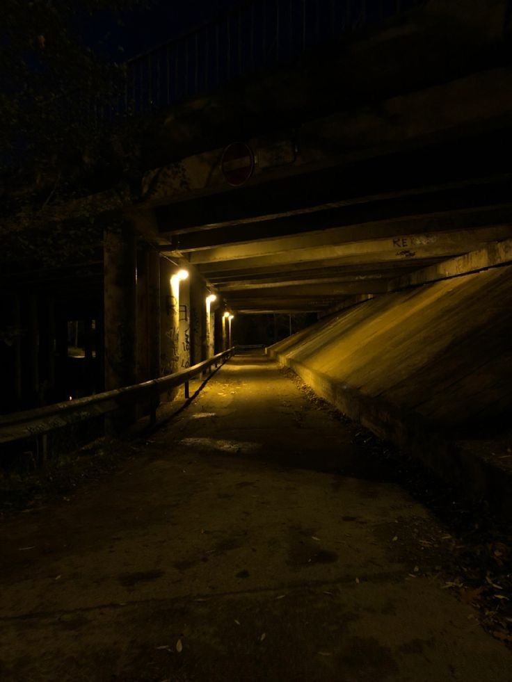 a dark tunnel with lights at the end