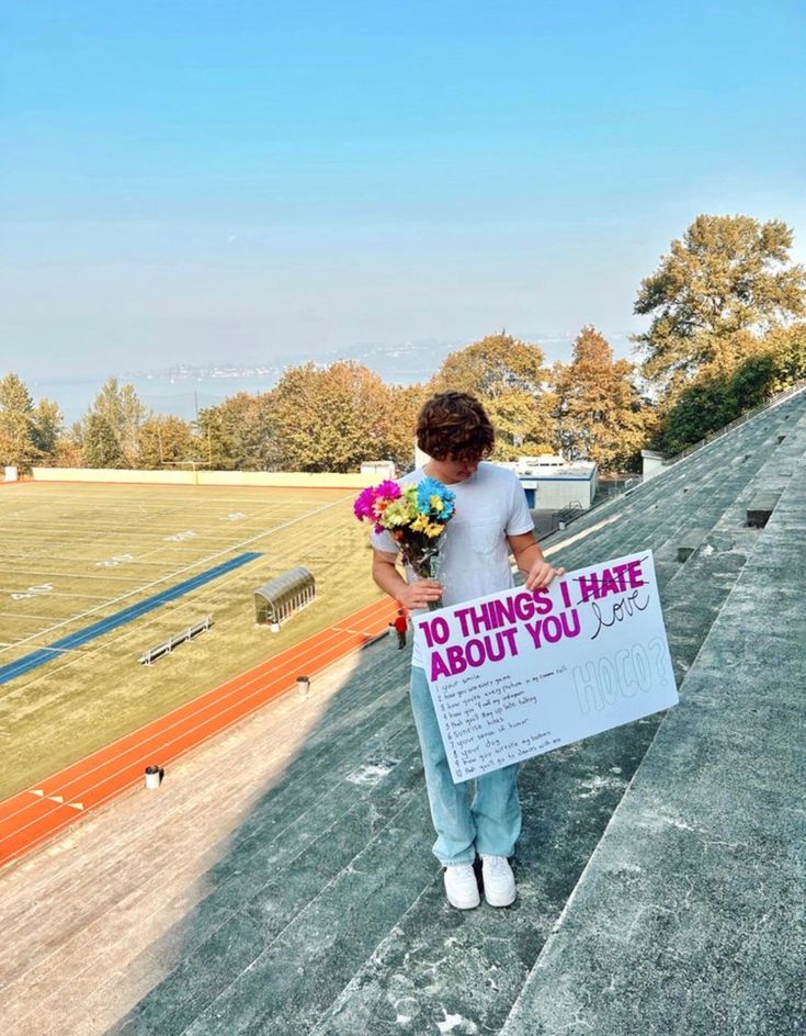 a woman holding flowers and a sign that says 10 things i hate about you on it