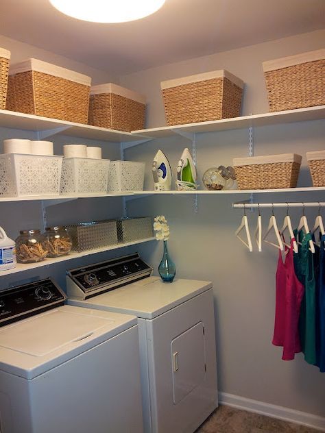 a washer and dryer in a laundry room with baskets on the shelves above