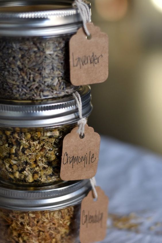 three jars filled with different types of herbs and labeled with labels on them, sitting on a table