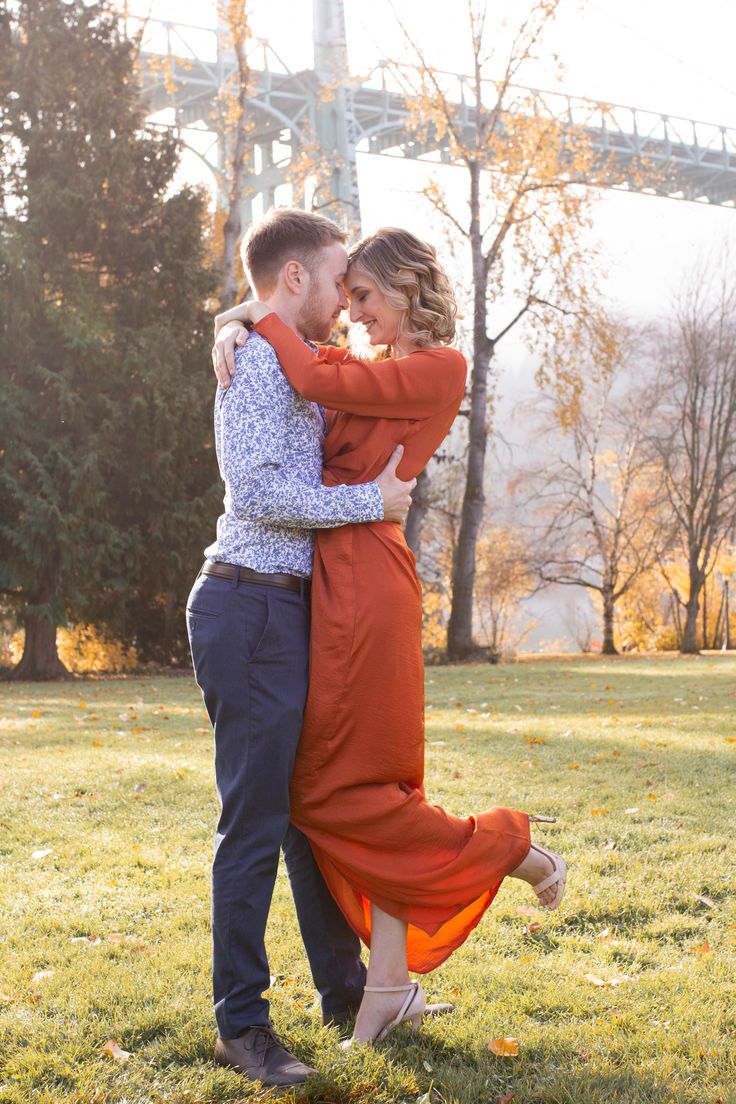 a man and woman hugging in the grass