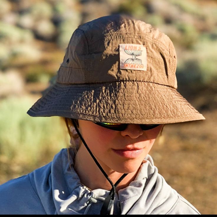 "The Vader 2 is a hybrid safari hat remixed with a bucket hat. We modified the popular safari hat with additions that we think are cool & important, like a plush water resistant material, that looks pimp but still serves a purpose. The Vader Helmet like fit thus the name.  Meet The Vader 2.  We used a light-weight weatherproof fabric that is like a nice camping tent that blocks out the weather but makes the most of its weight & size. We pushed it to our hiking standards and it blocked out the sun on most angles and the weight of the hat felt like nothing on. This design also allows you to throw it in the wash with your other clothes once it gets dirty  Available In Black & Khaki 🧵 ● Weather-Resistant Shell ☔️ ● One Size Fits Most 📏 ● Adjustable Chin Strap 👍 ● Adjustable Buckle ⑄ ● Shipp Brown Uv Protection Bucket Hat, Brown Curved Brim Sun Hat For Outdoor, Brown Brimmed Bucket Hat With Upf 50+, Safari Style Hat With Short Brim For Outdoor, Safari Hat With Short Brim For Outdoor, Short Brim Bucket Hat With Upf 50+ For Outdoor, Outdoor Safari Hat With Short Brim, Outdoor Bucket Hat With Upf 50+ And Short Brim, Safari Hats With Upf 50+ For Outdoor