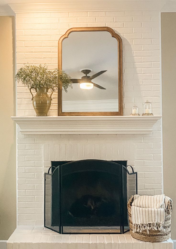 a white brick fireplace with a mirror above it