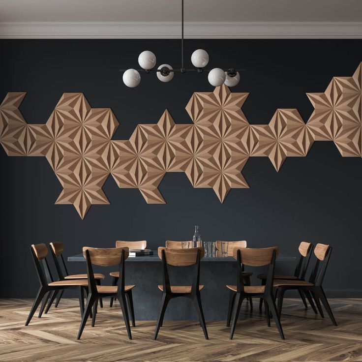 a dining room table and chairs in front of a wall with geometric shapes on it