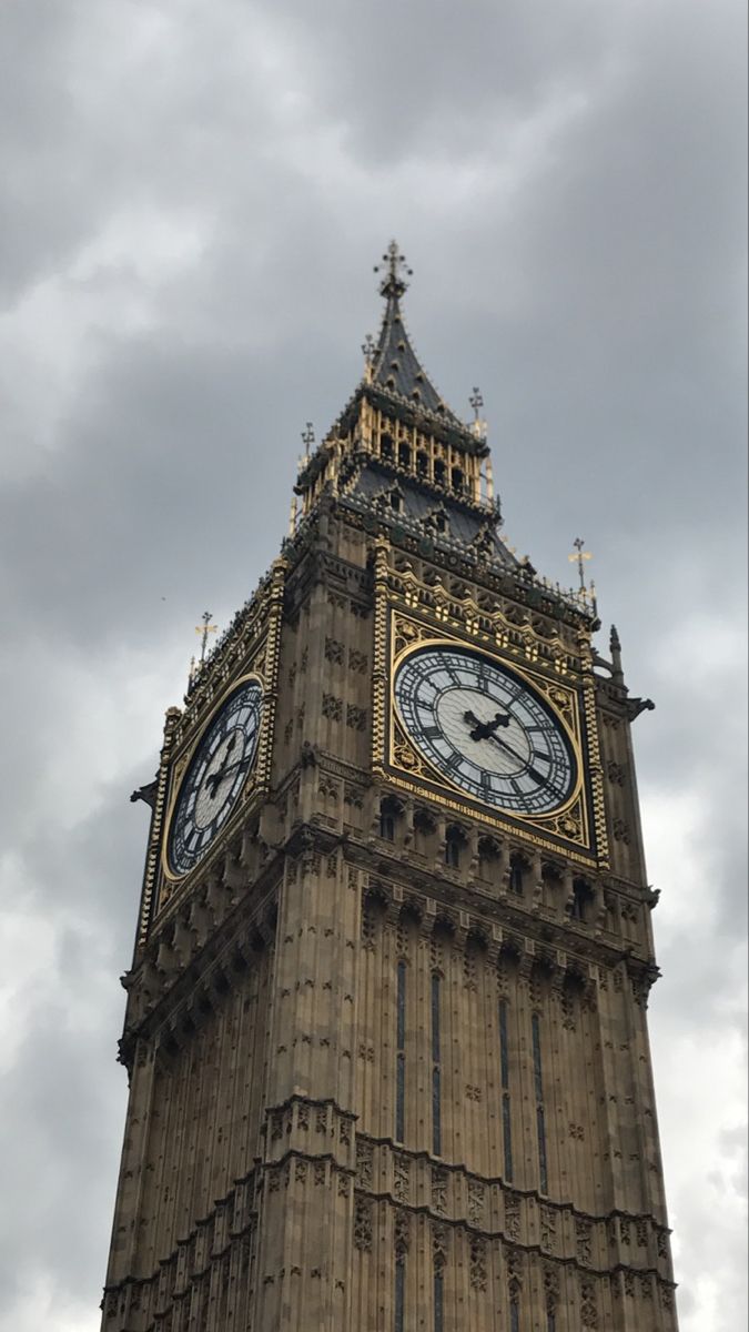 the big ben clock tower towering over the city of london, england on a cloudy day