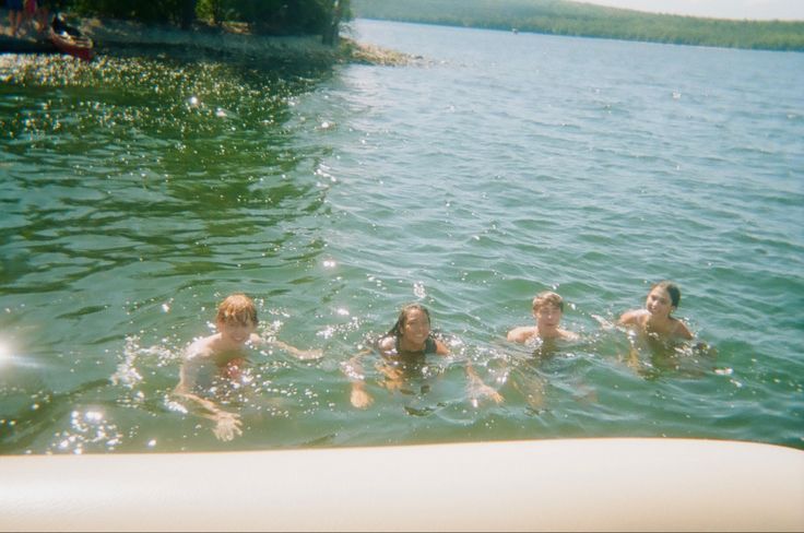 four people are swimming in the water together