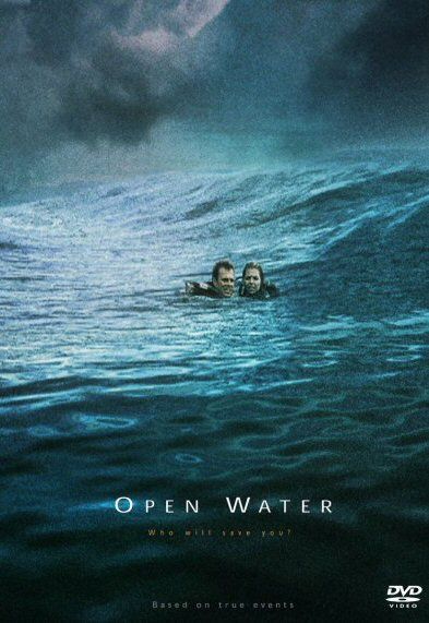 two people swimming in the ocean under a cloudy sky with an open water sign above them