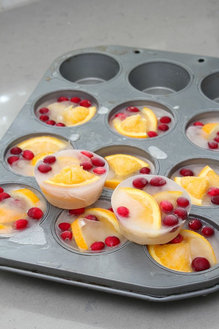 cupcakes with orange slices and cranberries in a muffin tin