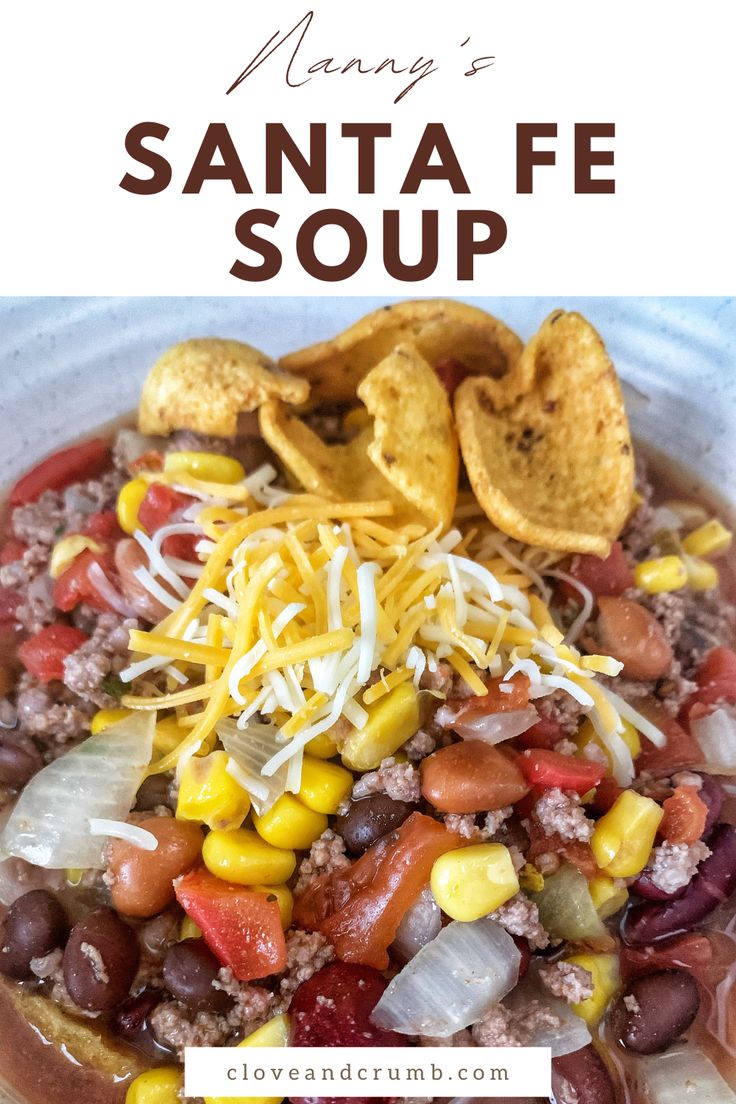 a white bowl filled with beans, corn and cheese next to tortilla chips