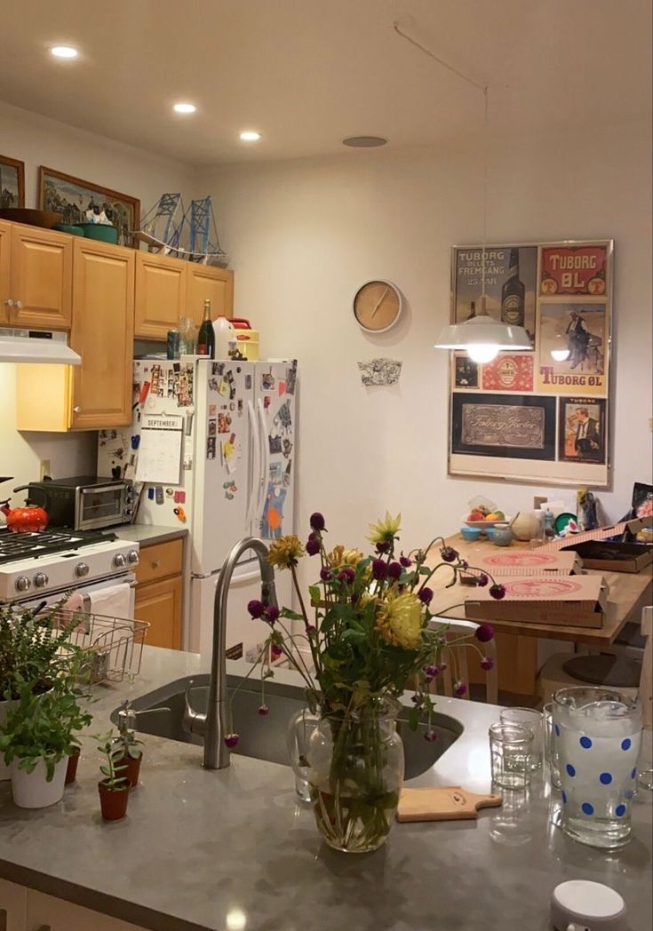 a kitchen filled with lots of counter top space and flowers in vases on the island