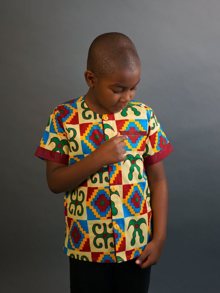 This short sleeved African Kente shirt is real cute. Dress him up in this cute African outfit and he will attract a lot of attention and draw tons of compliments. He can wear it whenever he wants to project his African Identity. He can wear it during Sankofa, Kwanzaa, and any African American or Afrocentric Cultural event. *Hand Sewn African Dress *Made by Local Artisans in Africa *100% Cotton *Made in Ghana *Portions of proceeds donated to charities in Africa *Everything in stock is available i Ankara Shirt, African Shirt, Dashiki Shirt, Ankara Fashion, African Shirts, Boy Shirt, Kwanzaa, African Men, African Inspired