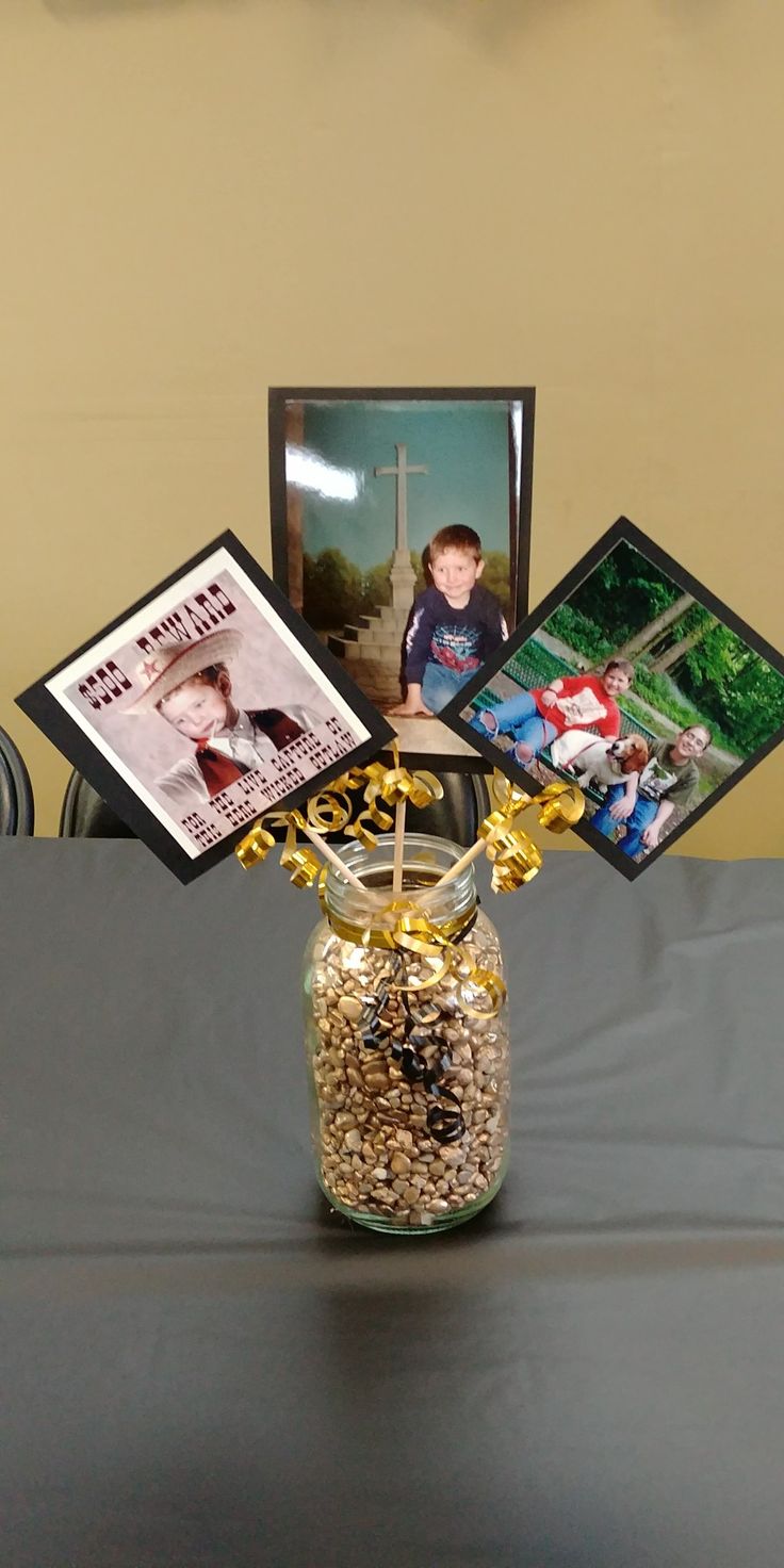 a vase filled with flowers and pictures on top of a table