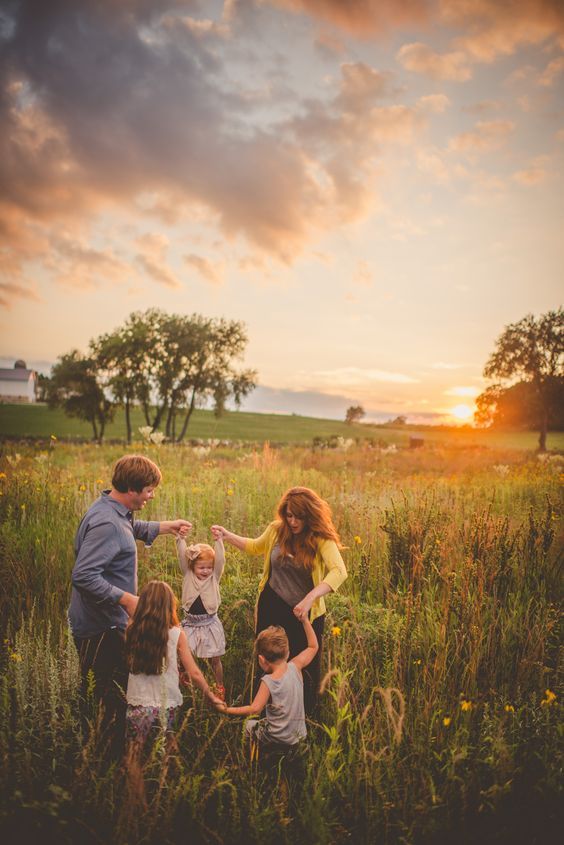 a family standing in a field at sunset