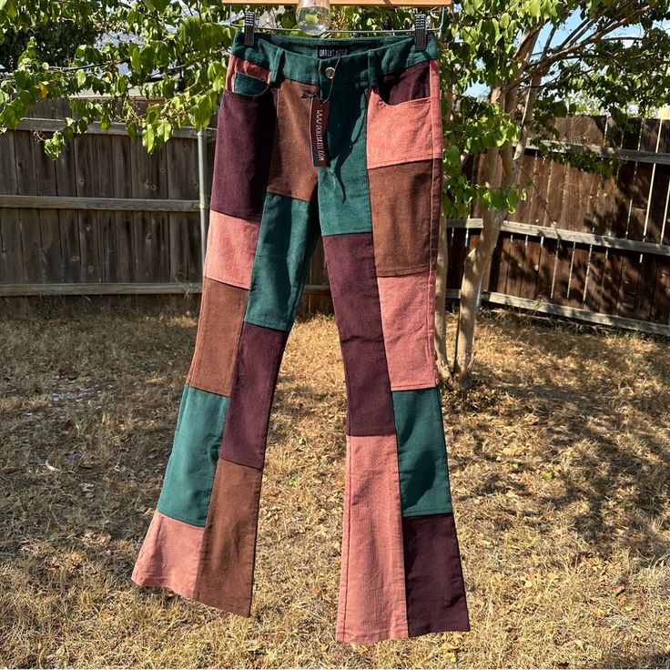 a pair of pants hanging on a clothes line in the yard with grass and fence behind them