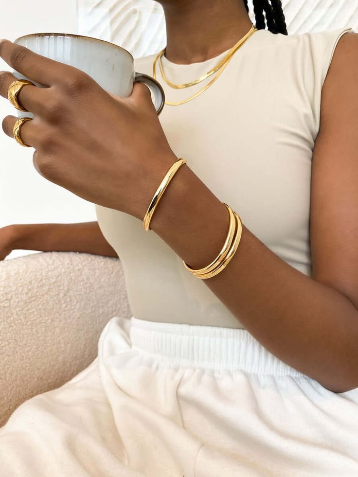 THE LOLA BANGLE - Is a simple bangle that is designed to be your go to piece for any time, any day. Features: Available in 18k gold plated stainless steel and stainless steel in silver Lifetime product guarantee All our jewelry is made to last, but visit our care page for more information on how to care for your JWLS. Simple Gold Accessories, Gold Jewelry Fashion Bracelet, 18k Gold Plated Jewelry, Gold Bangle Stack, Bangles Outfit, Gold Accessories Outfit, Gold Thick Bracelet, Gold Jewellery Bangles, Bangles Jewelry Designs Gold