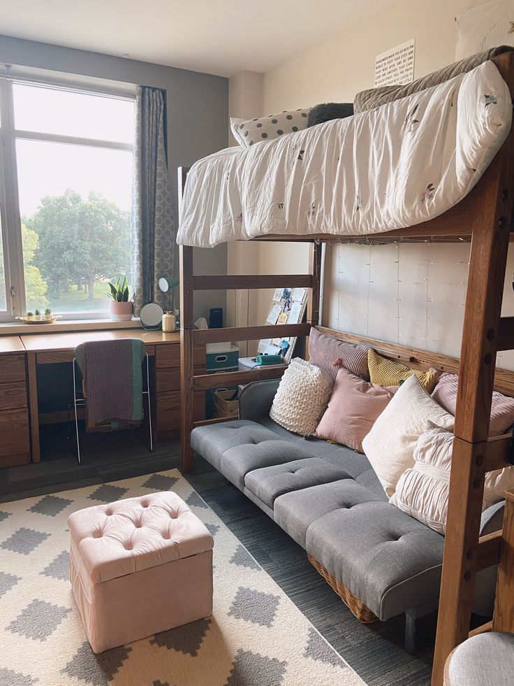 a bunk bed sitting next to a window in a room with a rug on the floor