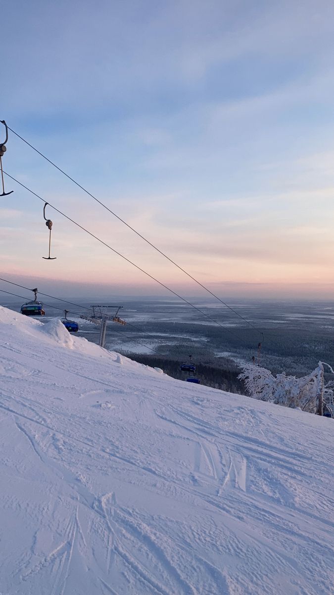 a ski lift going up the side of a snow covered slope