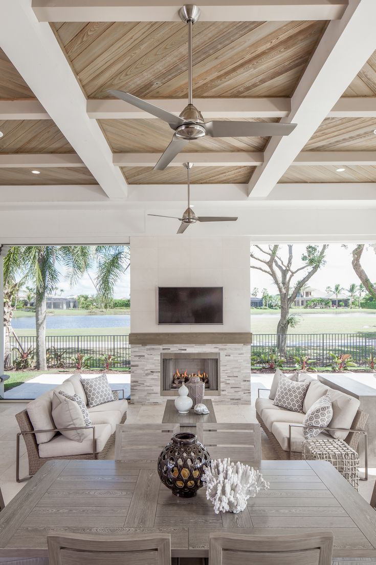 a living room filled with furniture and a flat screen tv mounted to the wall over a fire place