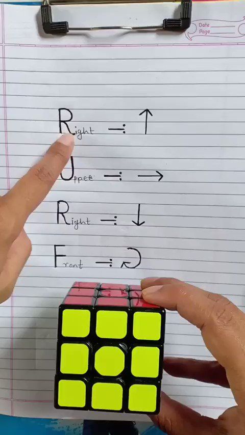 someone is holding a rubik cube in front of a piece of paper with numbers on it