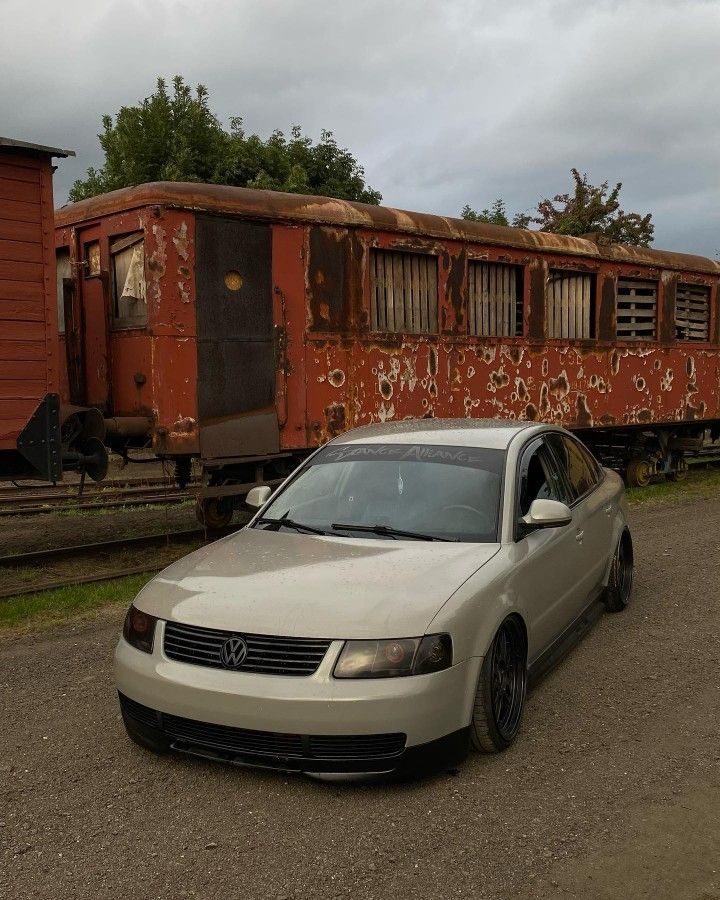 a car is parked in front of a train