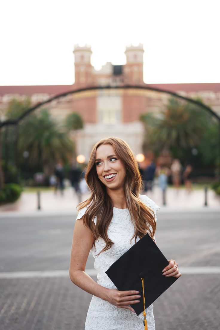 a beautiful young woman holding a graduation diploma