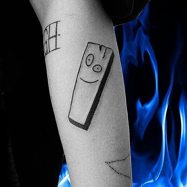 a person with a tattoo on their arm that has a lighter drawn on it and blue flames in the background