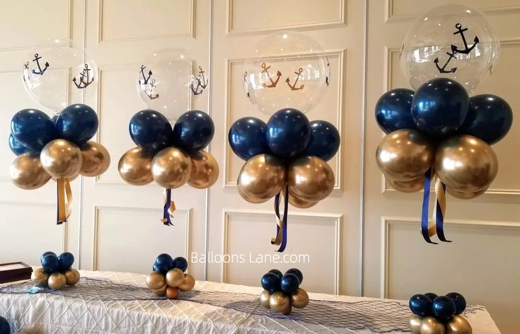 some balloons are hanging from the ceiling in front of a table with an anchor on it