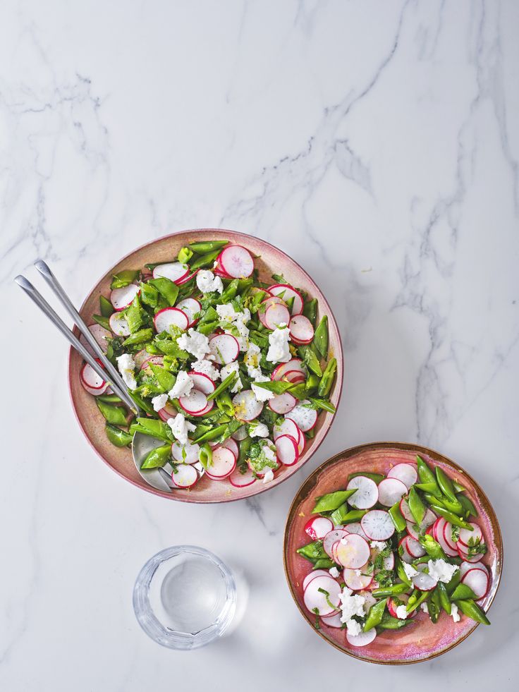 two bowls filled with vegetables on top of a table