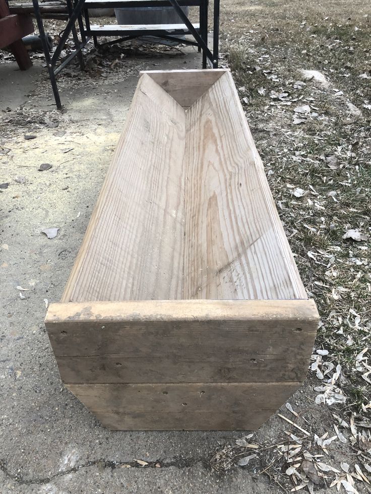 a wooden bench sitting on top of a dirt field