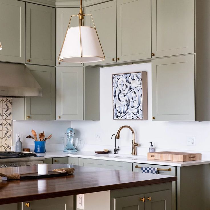 a kitchen with gray cabinets and wooden counter tops