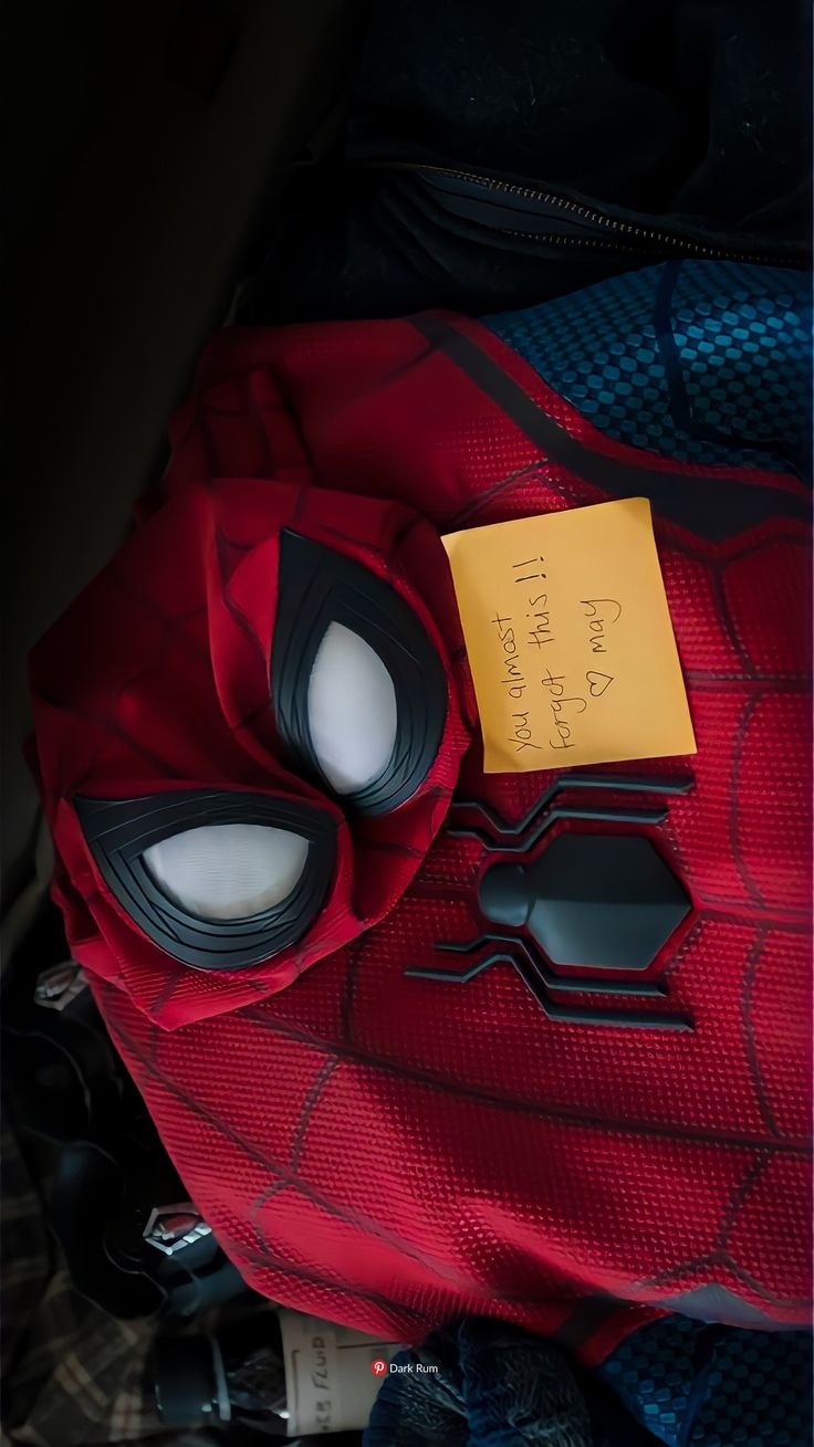 a spider - man costume and other items are on the back of a backpack