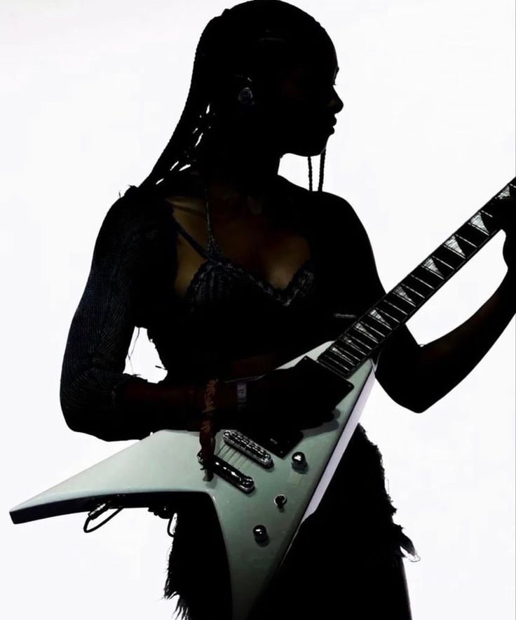 a woman holding an electric guitar in her hands