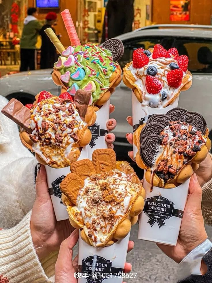 three people holding ice cream sundaes in front of a car