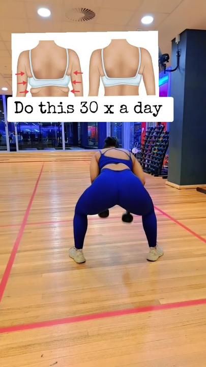 a woman in blue leggings and bra top doing squat exercises on a wooden floor