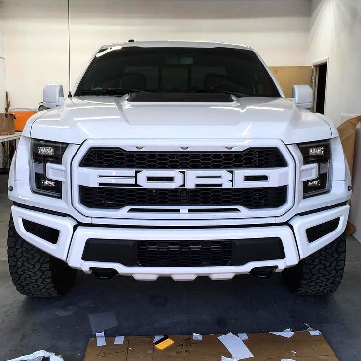 the front end of a white truck parked in a garage