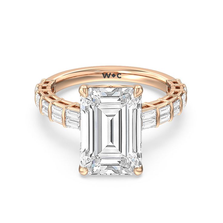 an emerald cut engagement ring with baguets on the shoulders and side stones in rose gold