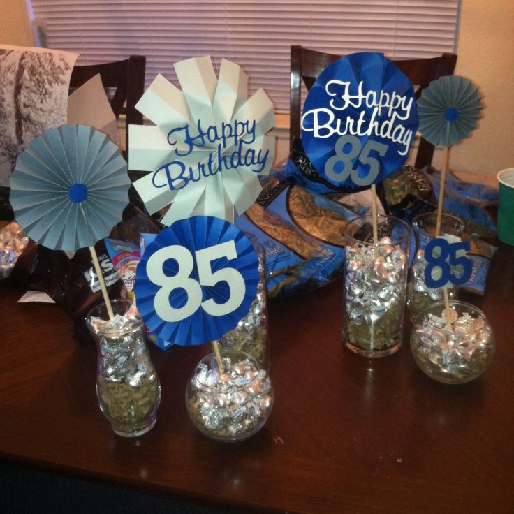 the table is set up for an 85th birthday party with decorations and paper fans