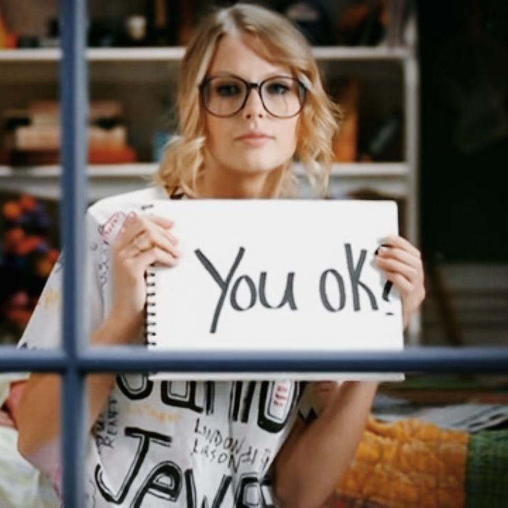 a woman holding up a sign that says you ok