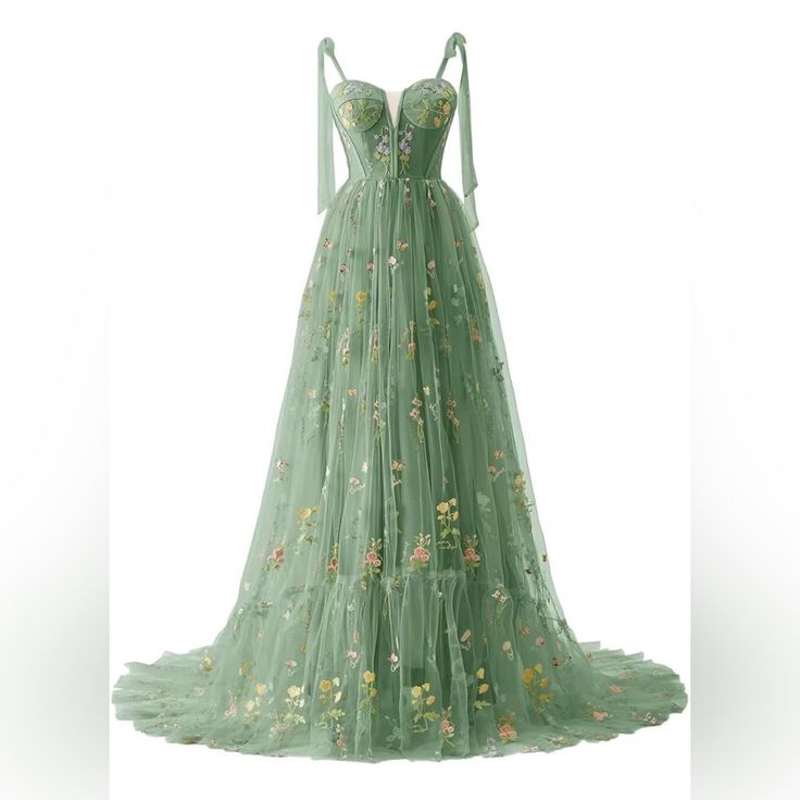 a green dress with flowers on the bottom and straps at the waist, in front of a white background