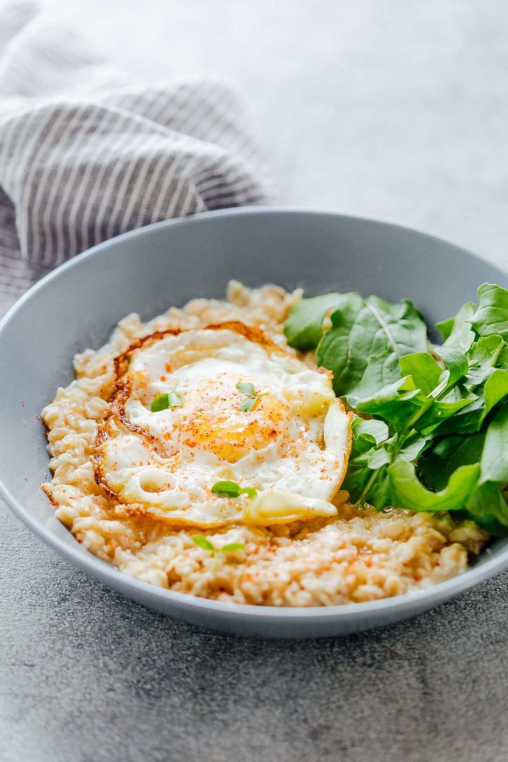 a bowl filled with rice, spinach and an egg