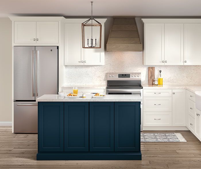 a kitchen with white cabinets, blue island and stainless steel appliances in the center area