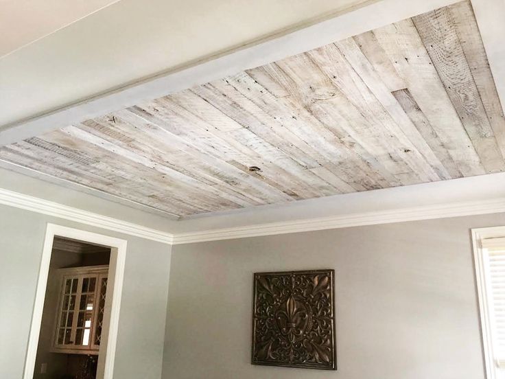 the ceiling is made out of wood planks and has been painted with white paint