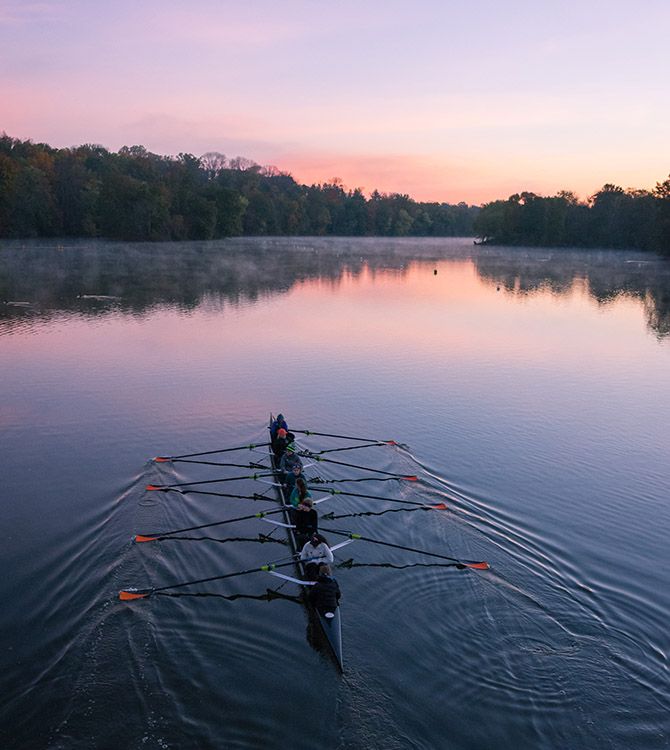 two rowers are rowing in the water at sunset