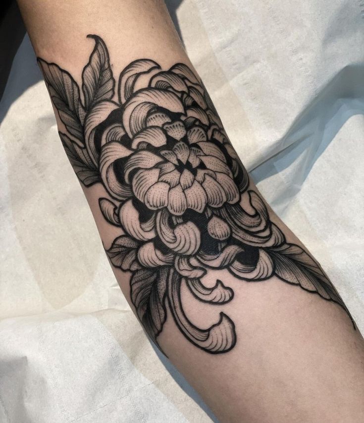 a black and white flower tattoo on the arm