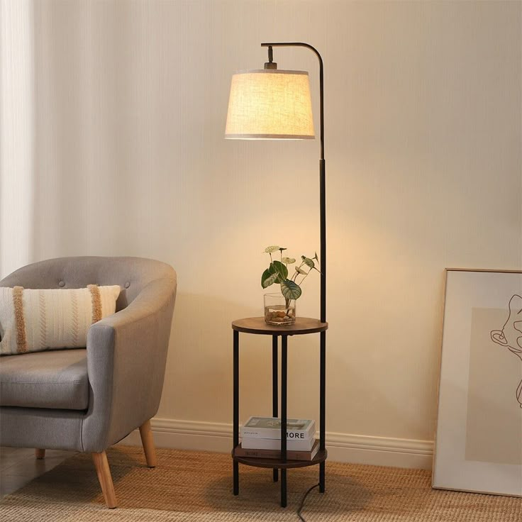 a living room with a chair, lamp and pictures on the wall in front of it