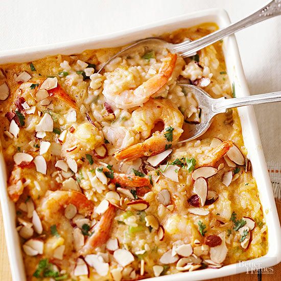 shrimp and rice casserole in a white dish with two serving utensils