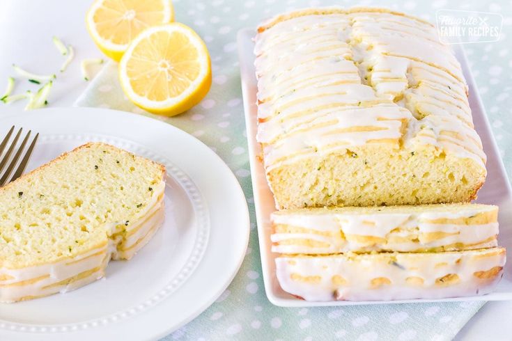 a loaf of lemon poppy seed bread on a plate next to a sliced loaf of lemon poppy seed bread