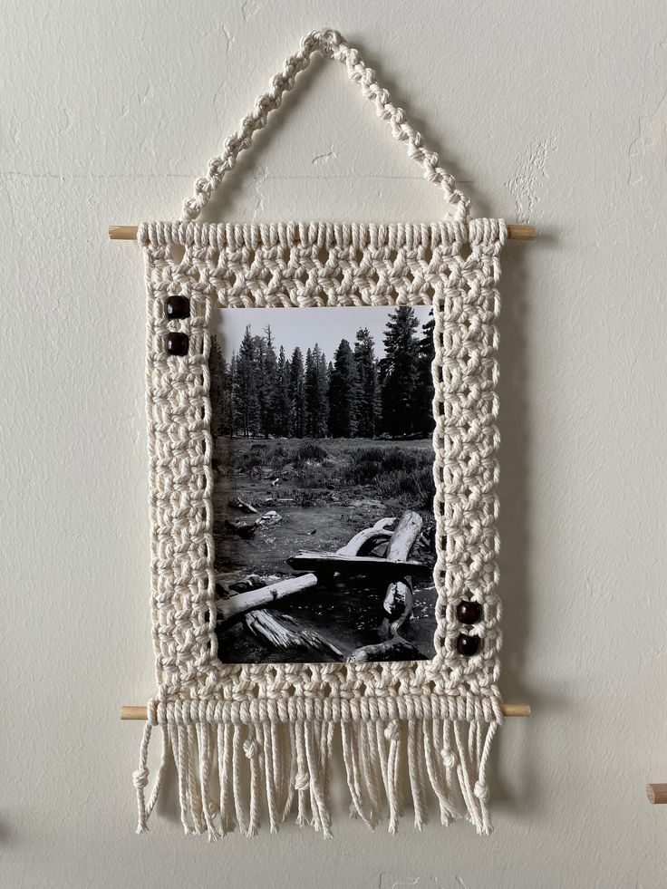 an old photo hanging on the wall with some tassels attached to it,