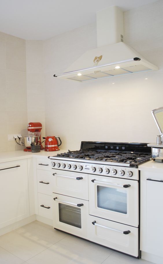 a white stove top oven sitting inside of a kitchen