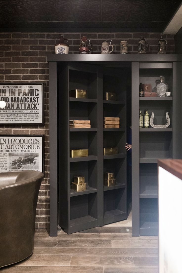 a room with brick walls and shelves filled with books, candles and other items in it